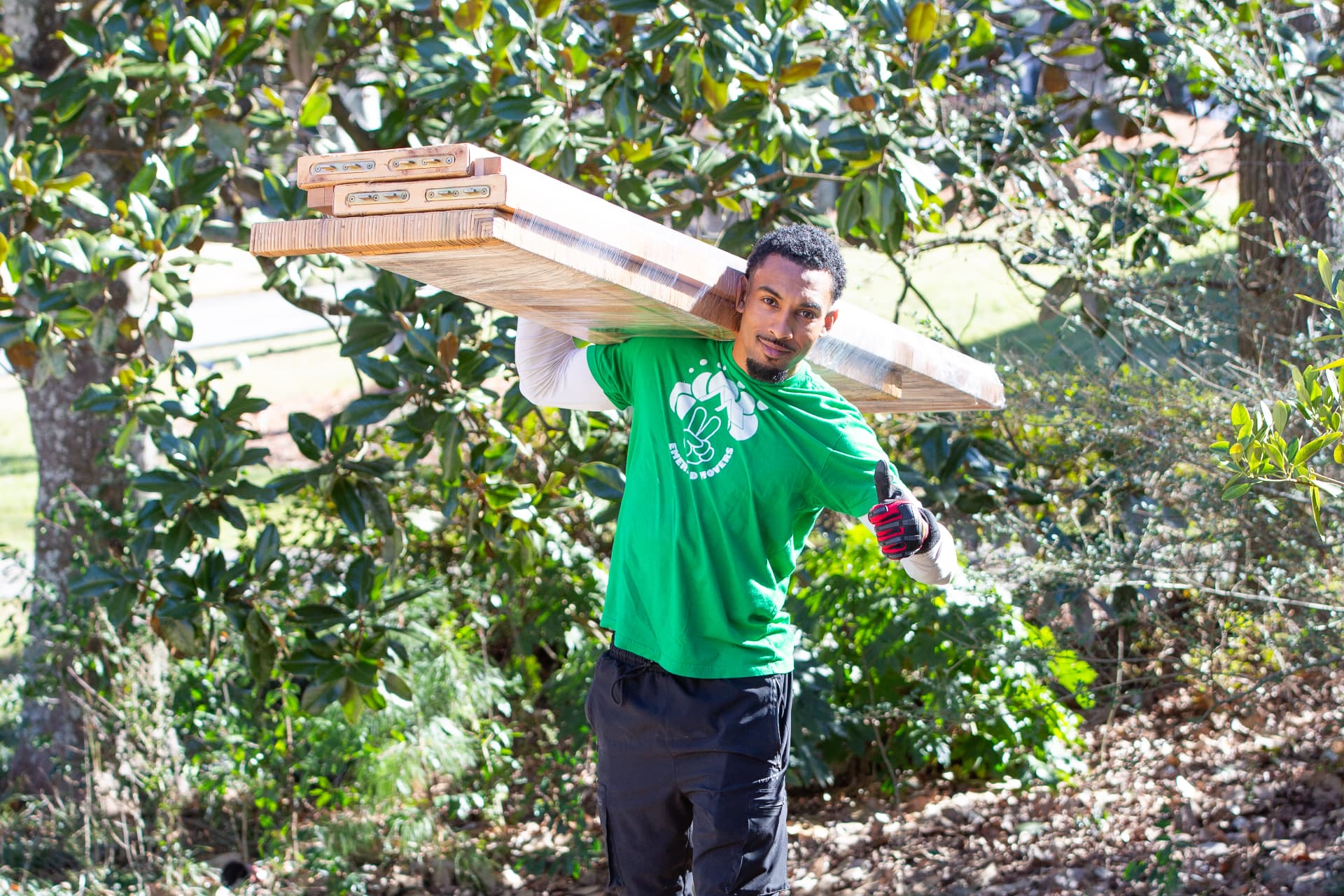 Emerald Movers team member carrying a shrink-wrapped table on his shoulder